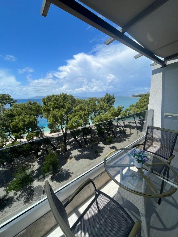 a balcony with a table and chairs and the ocean at Luxury apartment Alexandar in Makarska
