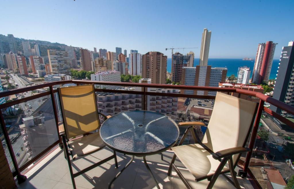a balcony with a table and chairs on top of a city at TORREMAR 17-E Levante Beach in Benidorm