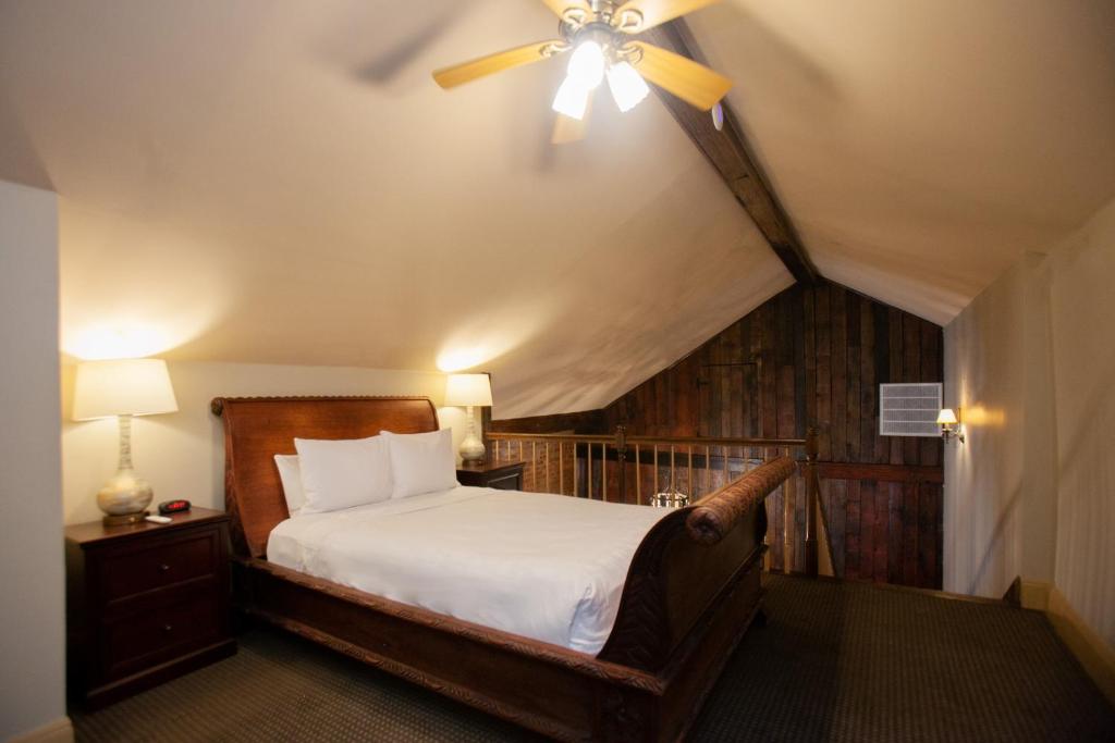 Chateau Hotel في نيو أورلينز: غرفة نوم بسرير ومروحة سقف