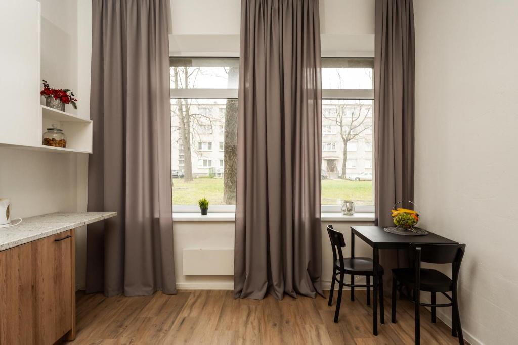 a kitchen with a table and chairs in front of a window at Air Apartment 220 in Vilnius