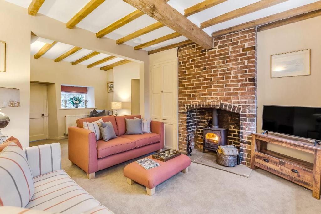 a living room with two couches and a fireplace at Brand Hill Cottage with Hot Tub in Loughborough