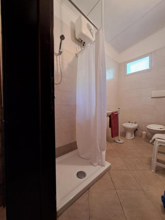 W łazience znajduje się prysznic z białą zasłoną prysznicową. w obiekcie Casa Solanas new w mieście Sìnnai