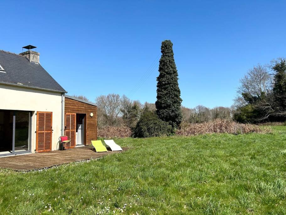 une maison avec terrasse dans un champ herbeux dans l'établissement Maison de charme dans la nature, à Clohars-Fouesnant