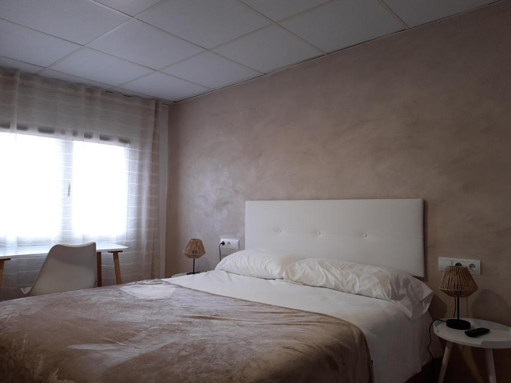Ulldemolins的住宿－Fonda Toldra，一间卧室设有一张大床和一个窗户。
