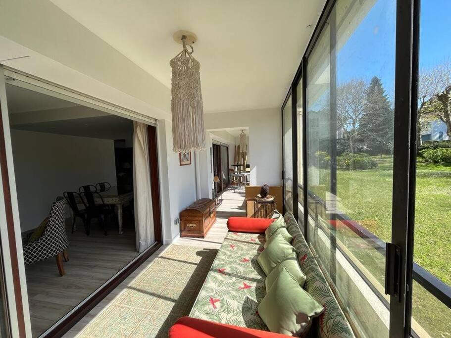 un salon avec un canapé et une grande fenêtre dans l'établissement Superbe T5 2mn à pied de l'océan, à Anglet