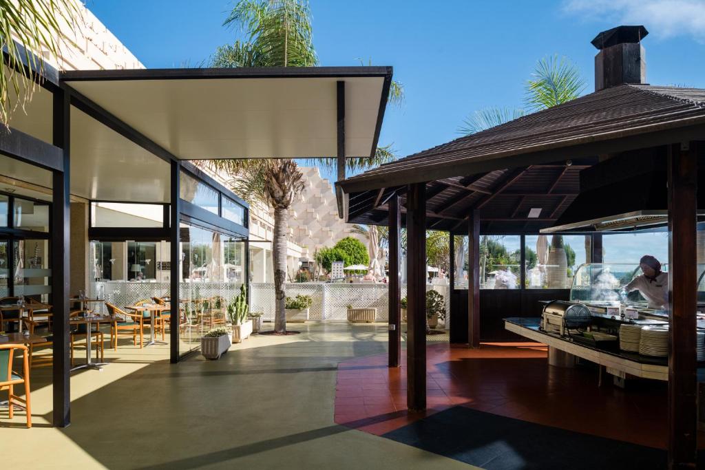 a patio with tables and chairs and a building at Alexandre Grand Teguise Playa in Costa Teguise