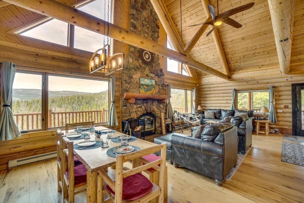 uma sala de estar com uma mesa, um sofá e uma lareira em Mountain-View Front Range Colorado Vacation Rental em Red Feather Lakes
