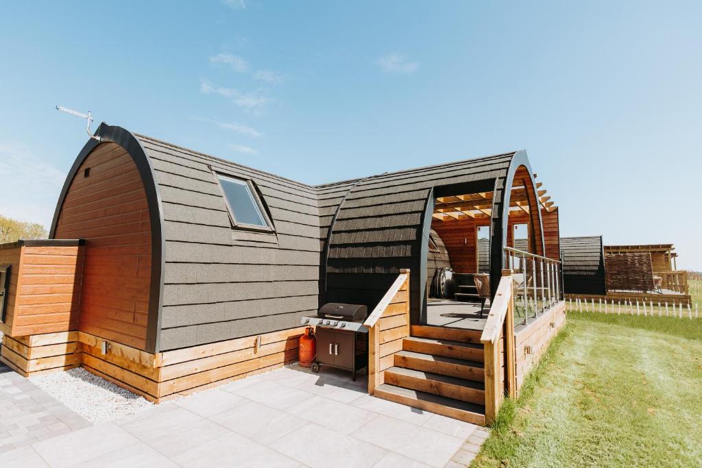 a tiny house with a deck and a patio at Gopsall Hall Farm in Atherstone