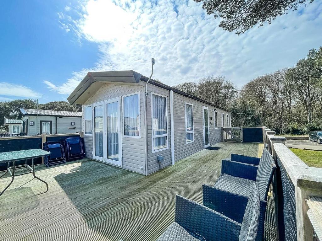 eine große Terrasse mit Stühlen und ein Haus in der Unterkunft Stunning Caravan With Wifi At Azure Seas Nearby The Beautiful Beach Ref 32057az in Lowestoft