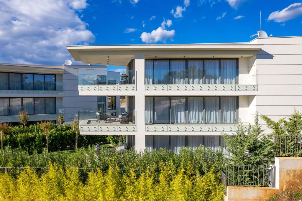 a white building with a lot of windows at HADRIE LUXURY RESORT AND VILLAS Krk in Krk