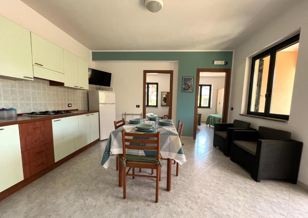 cocina y sala de estar con mesa y sillas. en Case Vacanza Calabria Ionica, en Cropani