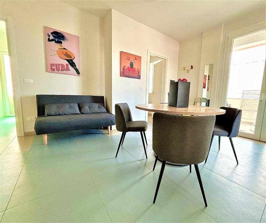 sala de estar con sofá, mesa y sillas en Suite Petrelli, en Torre dell'Orso
