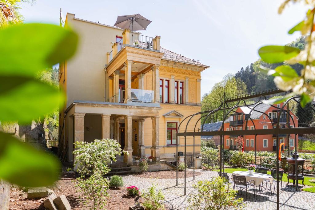 Una gran casa amarilla con un balcón en la parte superior. en Villa Emma, Wellness & Ayurveda, en Bad Schandau