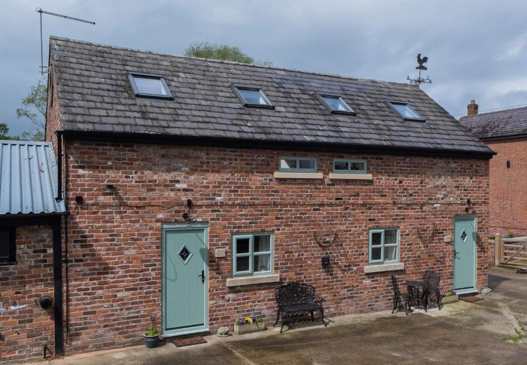 a red brick house with green doors and windows at The Hoglets 3 in Goostrey