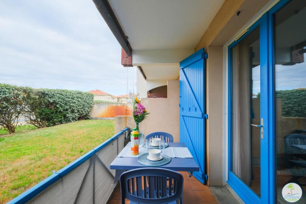 une table bleue sur le balcon d'une maison dans l'établissement Appartement avec Terrasse pour 2 ou 4 personnes classé 1 étoile, à Biscarrosse