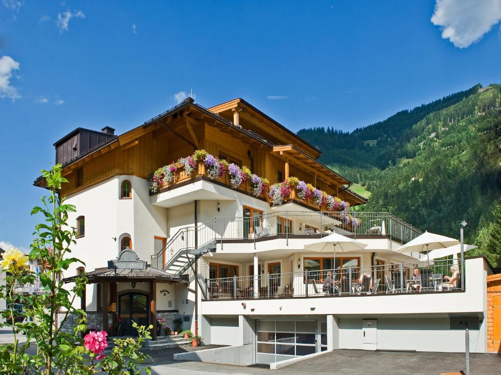 ein großes Gebäude mit Blumen auf dem Balkon in der Unterkunft Hotel Gratz Großarl in Großarl