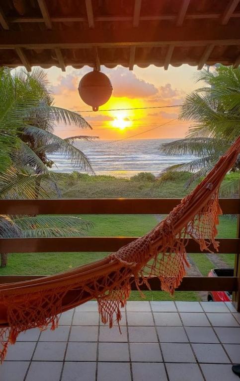 a hammock in a room with a view of the ocean at casa de praia a beira mar in Campina