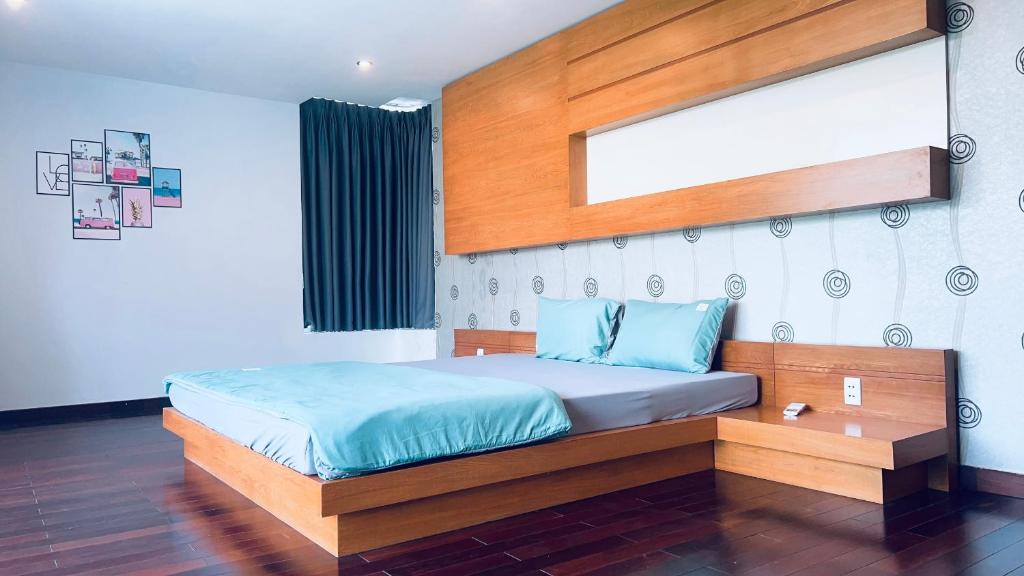 um quarto com uma cama e uma cabeceira em madeira em The Lux Villa Pool - Tran Phu em Vung Tau