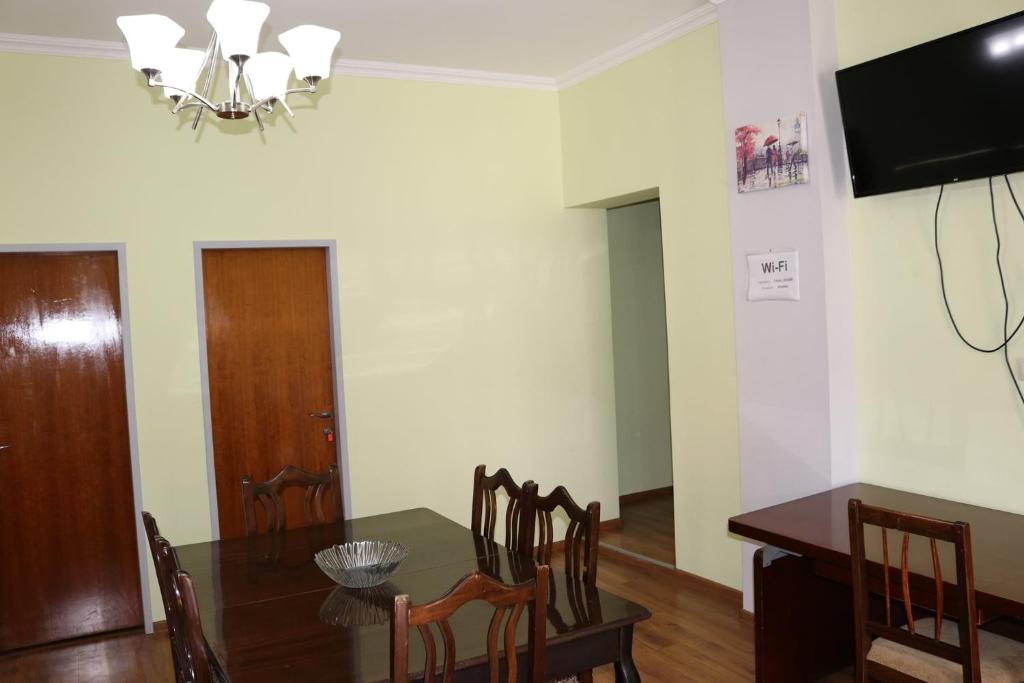 a dining room with a table and a television at Tvishi Guest House in Tsʼageri