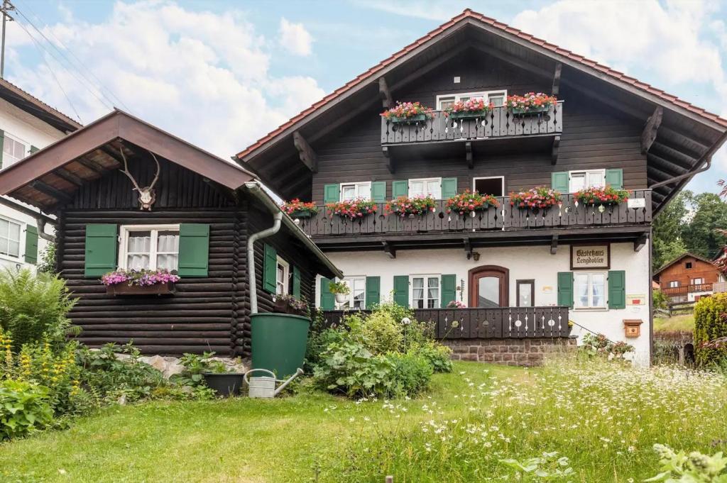 uma casa de madeira com caixas de flores nas varandas em Ferienwohnung - Hexi em Bad Kohlgrub