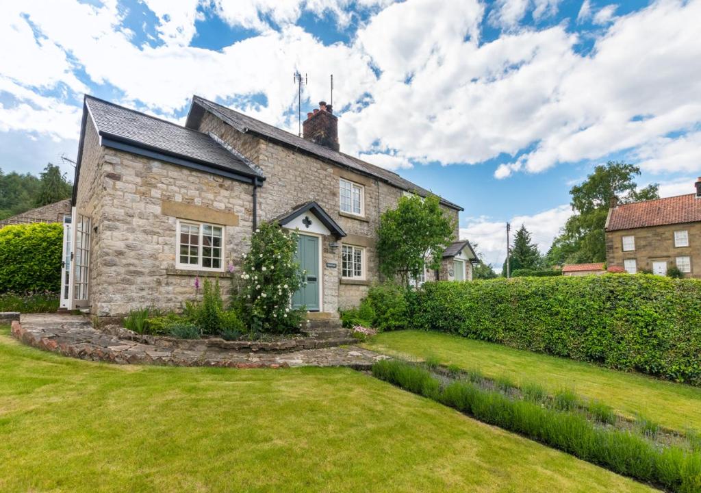 an old stone house with a green yard at Stoneleigh in Hutton le Hole