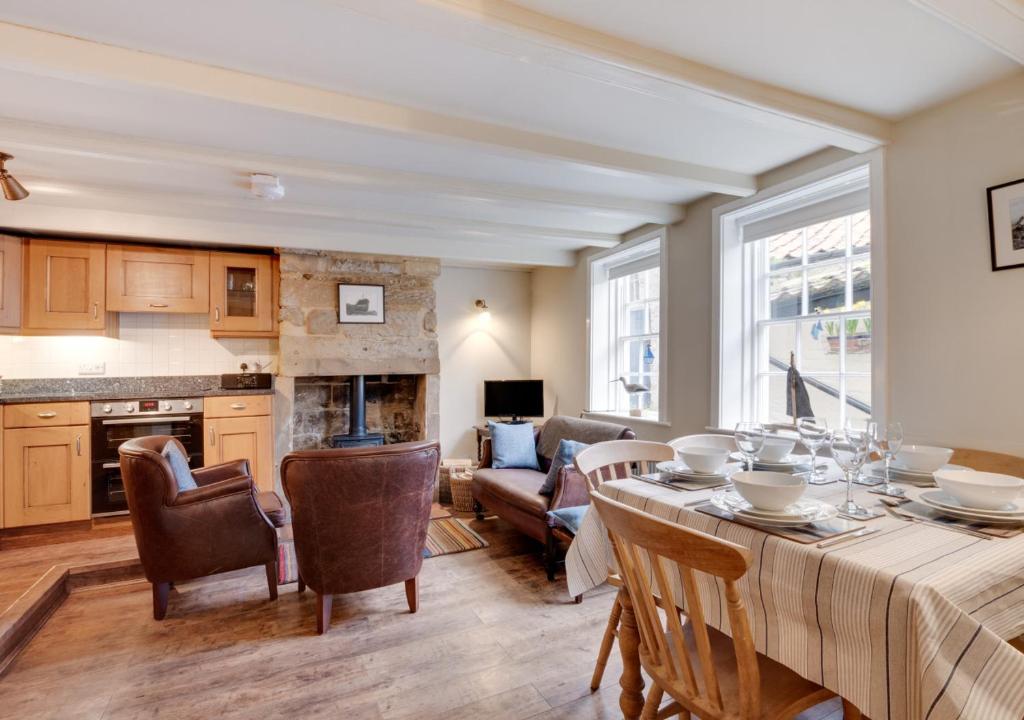 a kitchen and living room with a table and chairs at Storm Cottage in Robin Hood's Bay