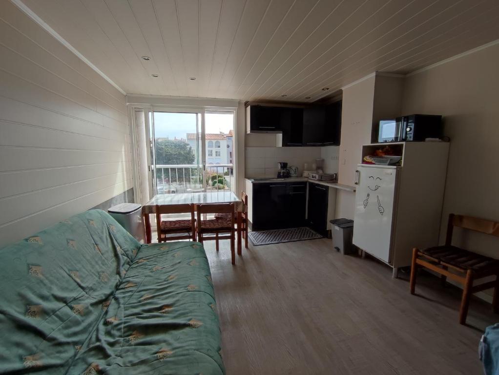un salon avec un canapé et une cuisine avec une table dans l'établissement LE COLISEE Joli studio cabine Mt St Martin proche port Cap d'Agde, au Cap d'Agde