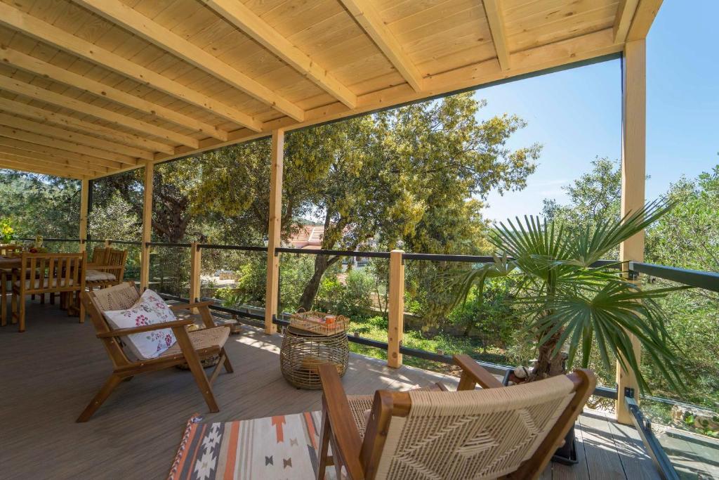 una veranda riparata con sedie, tavolo e pianta di Holiday Home Artina 1 a Lovište
