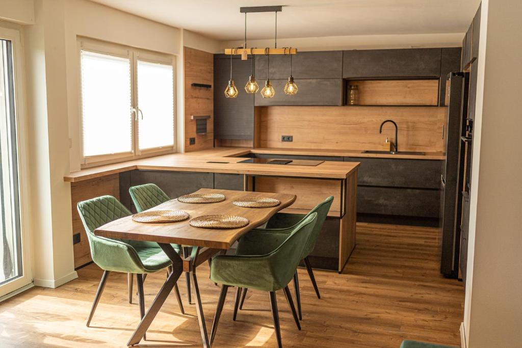 a kitchen with a wooden table and green chairs at Die entspannendste Wohnung am Edersee - SPA Sauna in Giflitz