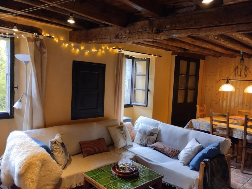un soggiorno con divano bianco e tavolo di La Maison du Carlit a Porté-Puymorens