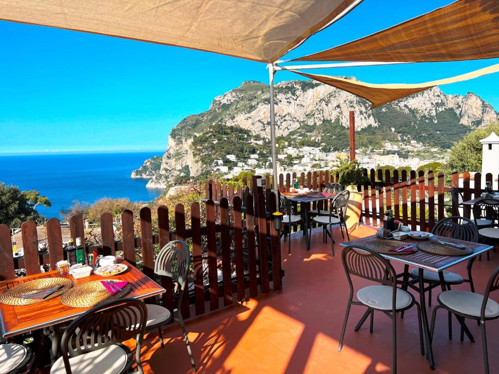 a restaurant with tables and chairs with a view of the ocean at La Reginella Capri in Capri