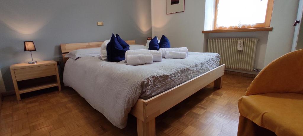 a bedroom with a large bed with blue pillows at Ai Grisi in Cavalese