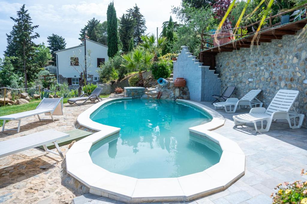 a swimming pool with two chairs and a table at Relais Bellavista Tuscany in Suvereto