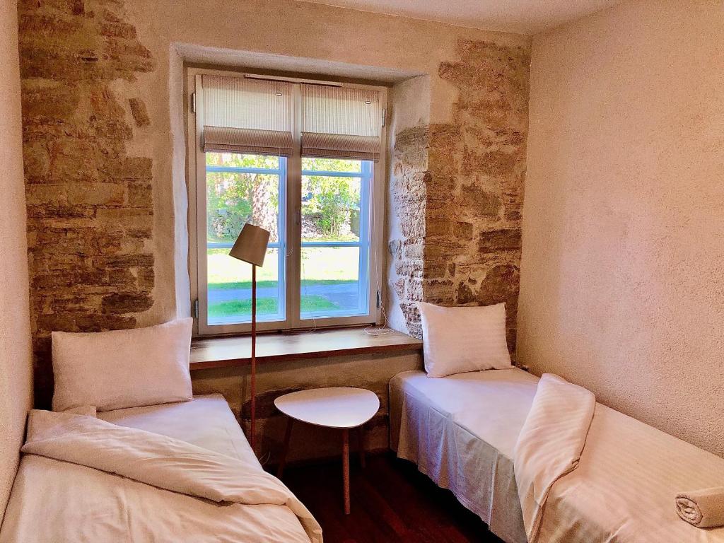 a room with two beds and a window at Kohtu Apartment Cozy in Kuressaare