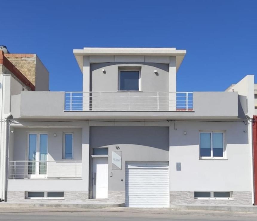 Cette maison blanche dispose d'un balcon. dans l'établissement Bilateral B&B, à Avola