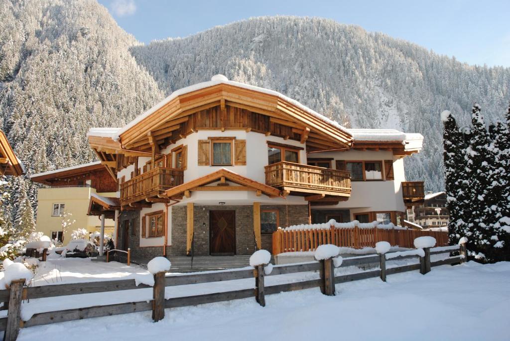 a house in the mountains with snow on the ground at Apart S'Dörfl in Mayrhofen