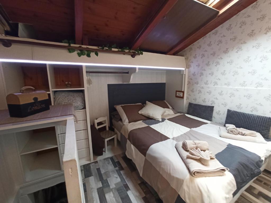 Habitación pequeña con 2 camas y escritorio. en La Casita, en Gijón