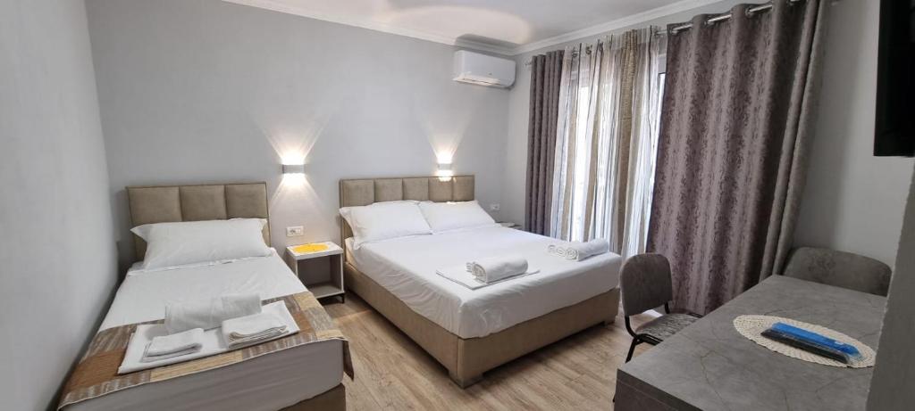 a hotel room with two beds and a table at AAA Apartment in Berat