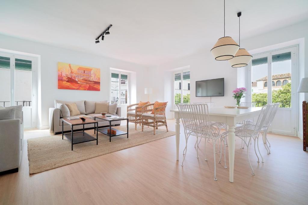 uma sala de estar branca com uma mesa e cadeiras em Orange Square Rooftop Apartment 250 m2 em Marbella