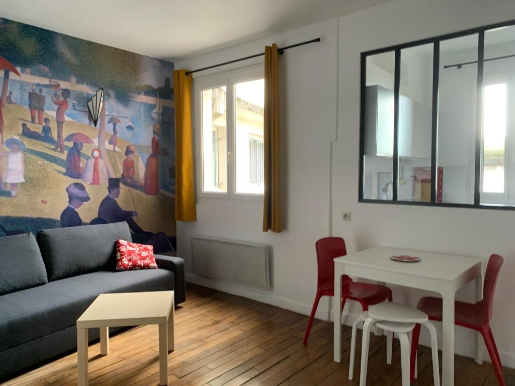 a living room with a couch and a table at Studio perfect for 2 adults and 1 kid, and up to 2 kids - Jourdain 20e, 25mn to Louvre via line M11 in Paris