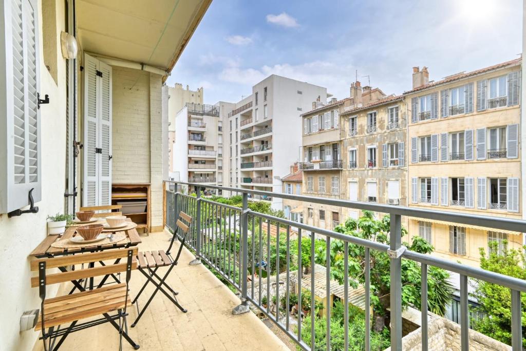 a balcony with a table and chairs and buildings at Cosy apartment located at 100 m from the beaches and the splendid corniche in Marseille