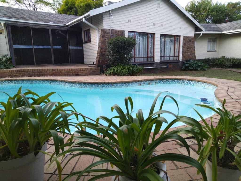 una piscina di fronte a una casa di Nzima BnB a Estcourt