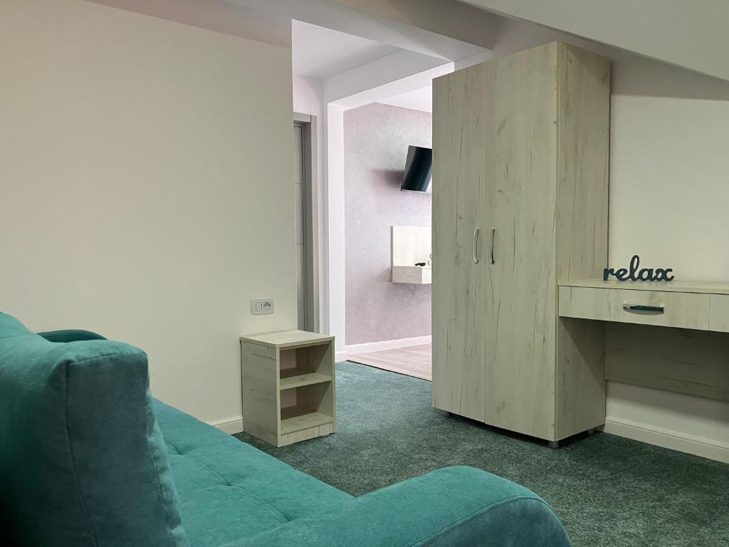 un salon avec un canapé bleu et une armoire dans l'établissement Private house, à Vaslui