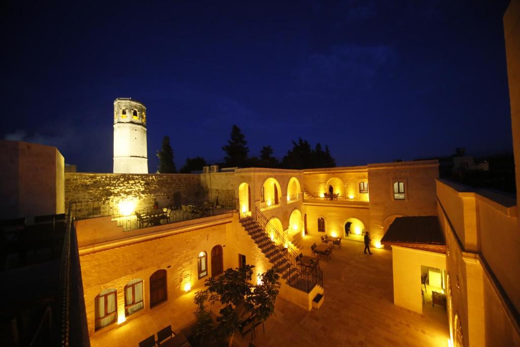 um edifício com um farol em cima à noite em PALMYRA BOUTIQUE HOTEL em Şanlıurfa