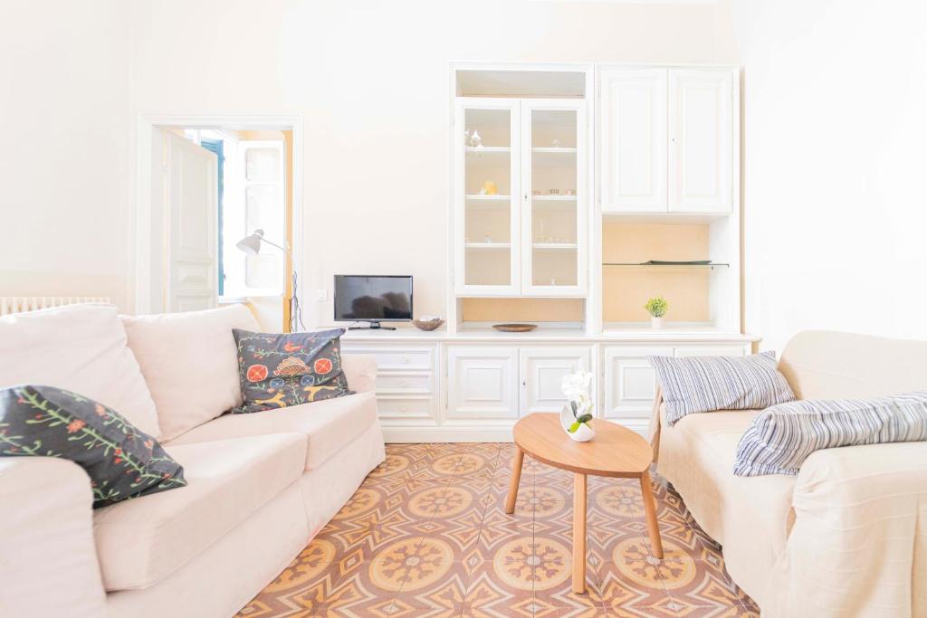 een woonkamer met een witte bank en een tafel bij 166 - Casa Mosaico, La Spezia vicino al centro città in La Spezia