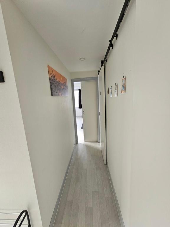 an empty hallway with white walls and wood floors at Le Bellevue in Givet
