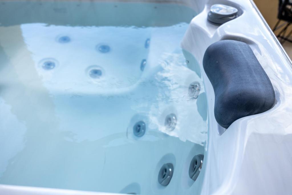 a bathtub filled with water with a black paddle at Votsalakia Hotel & Luxury Apartments in Selínia