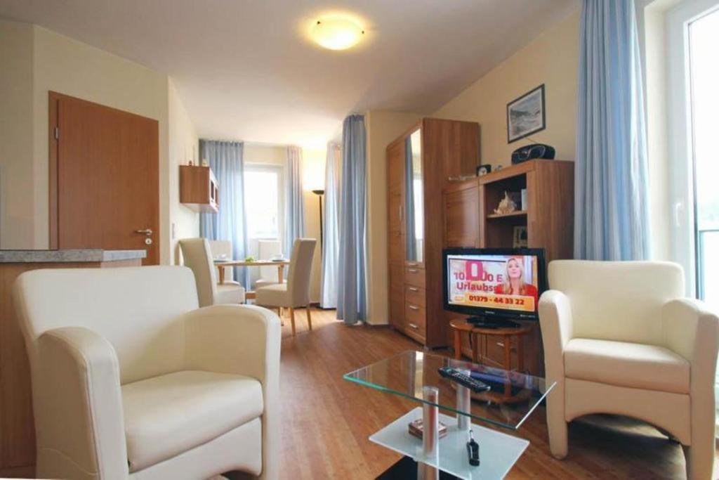 ein Wohnzimmer mit 2 Stühlen und einem TV in der Unterkunft Yachthafenresidenz - Wohnung 6201 / 742 in Kühlungsborn