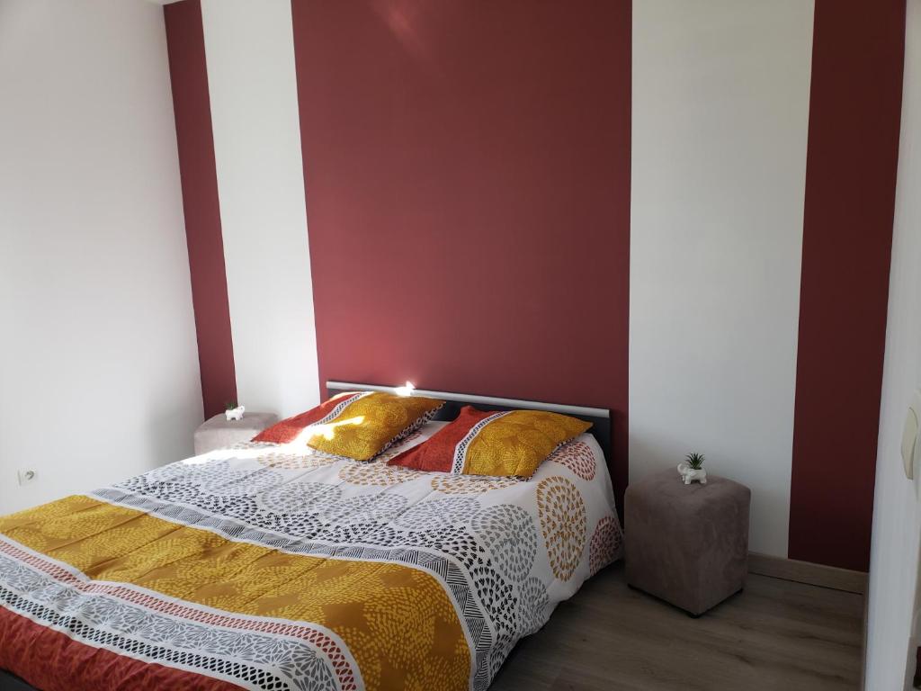 - une chambre dotée d'un lit avec un mur rouge dans l'établissement Chambre dans logement privé, à Yvré-le-Pôlin