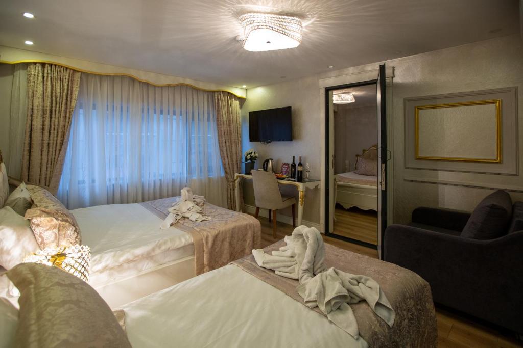 Sirkeci Ersu Hotel & SPA في إسطنبول: غرفة فندقية بسريرين وكرسي